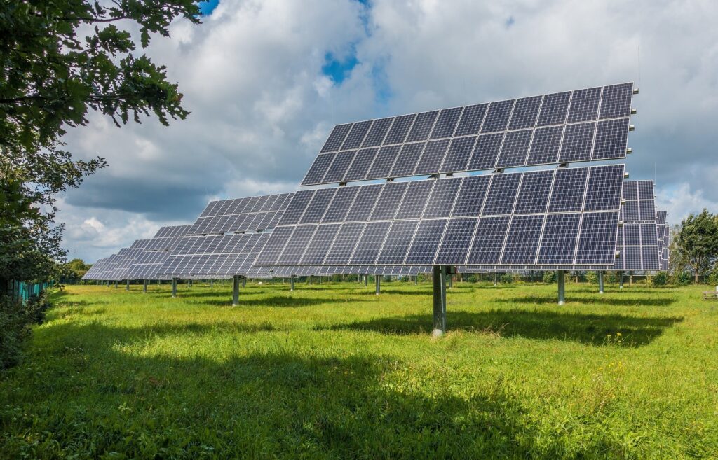 A large field of solar panels under a sky filled with clouds, showcasing a powerful solar system designed for efficient renewable energy production.